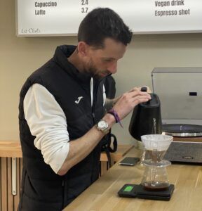 Prevención-cáncer-próstata-café Aaron Dueñas barista preparando café de especialidad con la V60